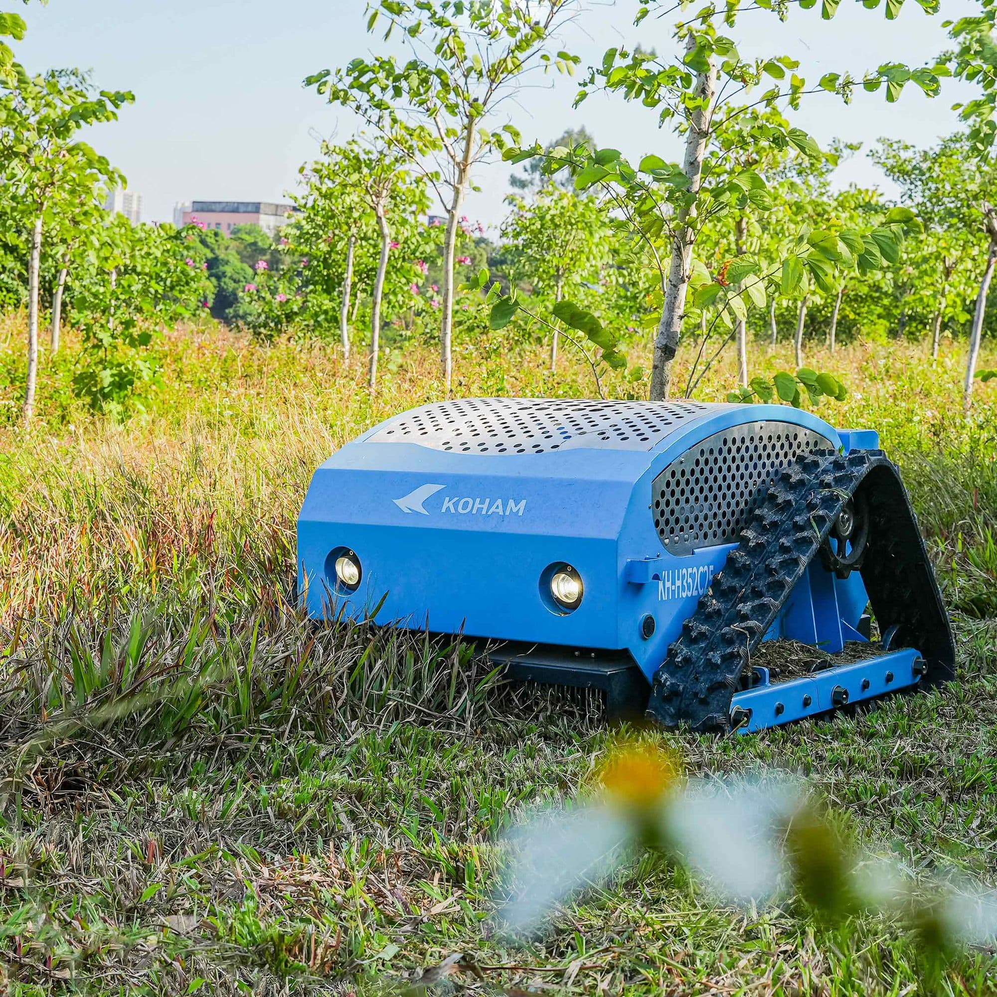 Tondeuse radiocommandée KOHAM KH-LM2425B dans une prairie arborée
